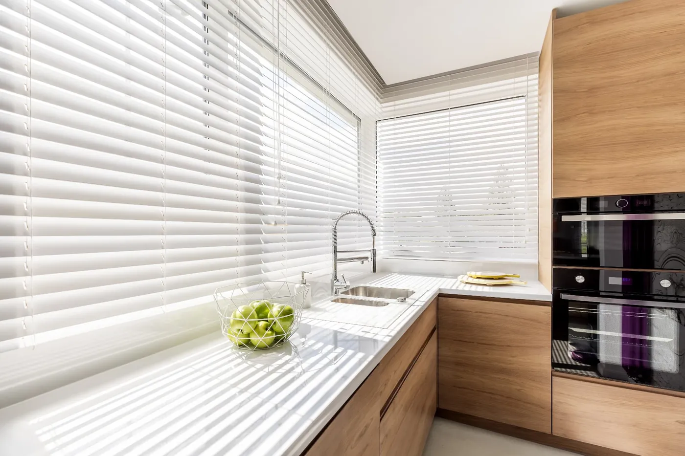 White venetian blinds filtering sunlight in a Vilamoura kitchen